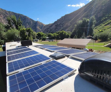 Panels on top of an RV with views of the mountains.